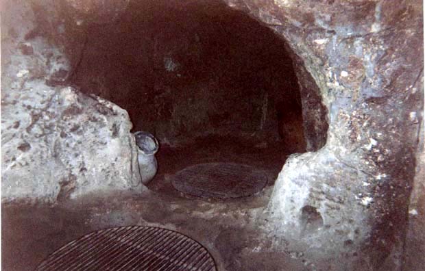 CAPADOCCIA: The underground city of Derikuyu (one of many in the area) was fascinating to tour, but no claustrophobics need apply. Even with the tunnels enlarged for bulky modern tourists, it's cramped going much of the time, and impossible to capture in a photograph. You climb through five levels of corridors, seeing rooms which were used as kitchens, bedrooms, schools, churches, and for all manner of other purposes for which they were used by months at a time by refugees from the villages up above in time of trouble. The gratings cover ancient airshafts. Smoke from their fires was routed through slanted tunnels to direct searchers away from their true location.