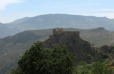 LAS ALPUJARRAS: Ruin on top of a rock viewed from the winding mountain road.