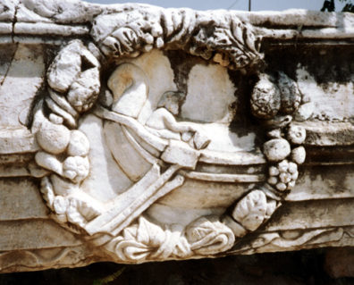 CORINTH: This fanciful Roman era relief depicts someone in a swan-prowed boat within a wreath of food.