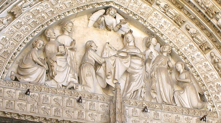TOLEDO: The tympanum depicts the 7th-century St. Idelfonso (patron saint of Toledo) receiving his chasuble from the Virgin Mary. He was especially noted for his devotion to Mary.