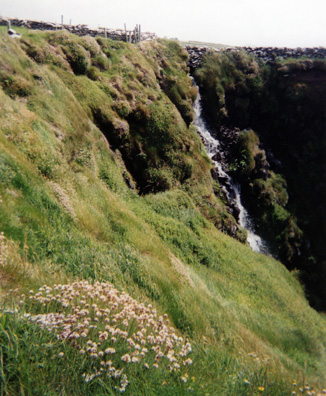 DINGLE PENINSULA: We were reminded of the wetness of Ireland by this cascade pouring down the slope by the fort into the sea.