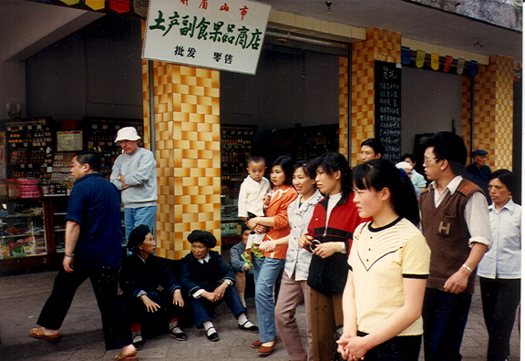 LESHAN: Three women in ethnic dress sitting in front of a shop (Doug Hughes standing in rear).