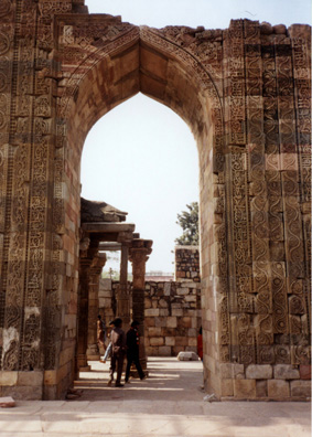 An elaborately carved stone archway, typical Mughal-style pointed arch gateway.