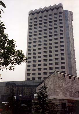 CHENG DU: At the airport, we had a long series of waits for our flight to Cheng Du. One cleaning woman was collecting duty-free plastic shopping bags and stowing them in a firehose compartment along with her lunch. There must have been a ready market for the bags: we saw them hanging in small private shops in Cheng Du. We arrived late at night in Cheng Du, me somewhat apprehensive about customs since I was bringing in a book of savage anti-Deng cartoons by a Hong Kong artist about the coming takeover in 1997; but the inspector didn't spot it. We were warmly welcomed by Mr. Cai Li, Associate Director for Foreign Relations of the Szechuan Education Commission. He had worked with Tom Kennedy some years before and proved an excellent guide and friend. But our intiial viws of the country were uninspiring. The airport looked bombed out and ugly, the roads were ugly, the air was polluted. My first surprise was spotting little roadside shops, open late at night, selling food, drinks, etc., with groups in them watching television. By daylight, Cheng Du was much more attractive. This was our comforable hotel. Plumbing by American Standard, elevators by Mitsubishi.