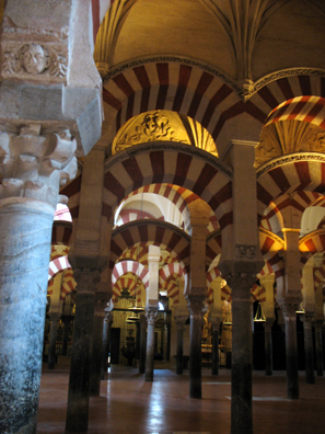 CORDOBA: The famed forest of pillars inside the great Mosque of Corcoba (La Mezquita), used classical pillars of various designs and heights, so their bases and capitals were adjusted to hold up arches of uniform heights. The arches themselves are built of alternating strips of stone and brick (though in the latest hasty addition to the building the red stripes were merely painted on). The capitals differ greatly in design from one another to keep the arches at the same level with each other. Begun in the 10th century.