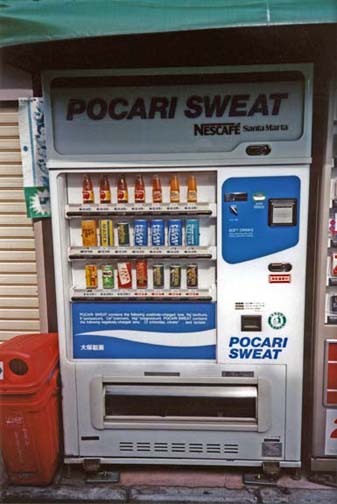 KYOTO: Canned drink machines are extremely common. Popular brands bear pseudo-Western names in sometimes odd English. This machine features the popular sports drink "Pocari Sweat." Also common, sweetened chilled coffee beverages in cans. May 14, 1998.