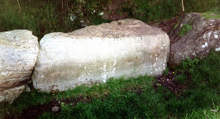 Brú na Bóinne: Of the many great stones surrounding the mound, eleven are decorated. This one is carved on the left with a sunburst design difficult to make out in the photograph. The largest of the stones used to build Newgrange is said to weigh 50 tons, far larger than those used at Stonehenge.