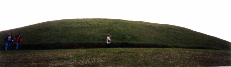 Brú na Bóinne: Knowth at first is less striking. Its interior shafts (oriented to the equinoxes) are less spectacular than Newgrange's, and it lacks the shining white exterior of the more famous mound. However, the archeologists here chose to leave the white rocks on the ground surrounding the mound, believing that was where they had originally been placed. However, in some ways it is even more impressive. It is actually the larger of the two, being over 275 feet in diameter.