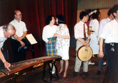 SZECHUAN MUSIC CONSERVATORY: Then followed a great concert of traditional folk music (some in modern arrangements) by faculty and students. Afterwards, we were invited on stage to try out the instruments. Above left, Doug examines a gu-zheng. Above right, musician holding a ruan.