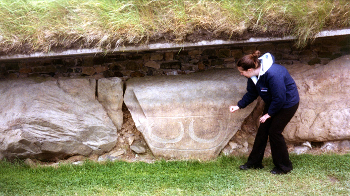 Brú na Bóinne: Our guide shows us a pattern of four engravings which look like lunar symbols (only the lower two appear clearly in the photograph).