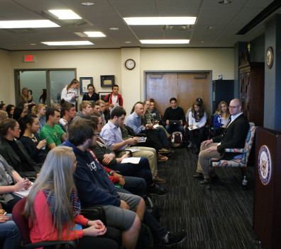 Group of people in classroom with speaker leading discussion.