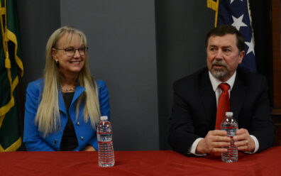 Mary Dye and Mark Schoesler speaking at table. 