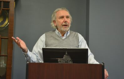 Lawrence Pintak speaking at podium. 