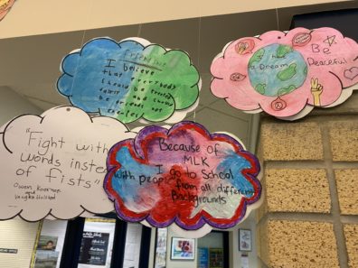 Mobile of paper clouds with students' writing.