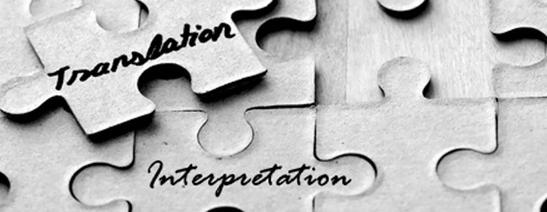 Puzzle pieces with the words "Translation" and "Interpretation" written in black ink.