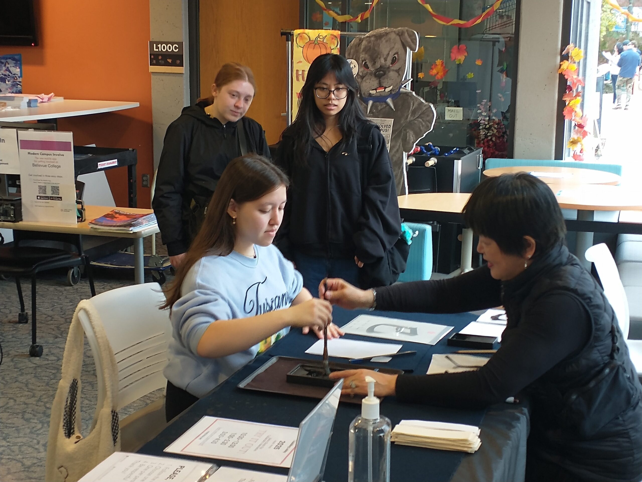Students practicing Japanese calligraphy with traditional brushes and ink