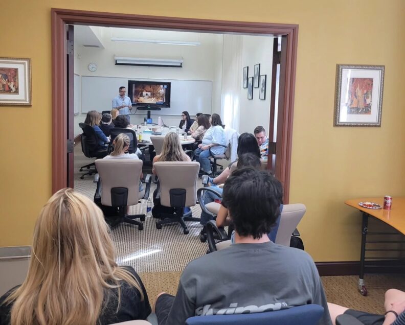 Students and faculty listen as Héctor Rendón introduces the presenters