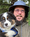 Todd Wilson with a pretty, tri-color shepherd or collie puppy.