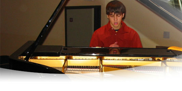 student practicing at grand piano
