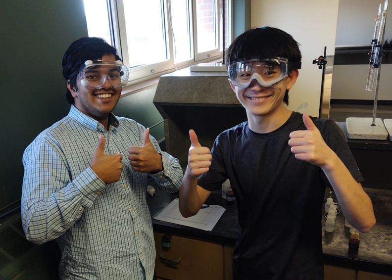Bose-Bandyopadhyay and Li wearing eye protection and giving thumbs up.