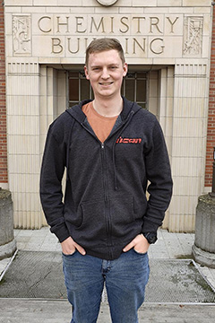 Miles McKeown stands in front of the entrance to the Chemistry Building.