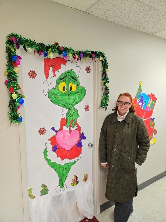 Linda Kildew standing next to her Christmas door decoration