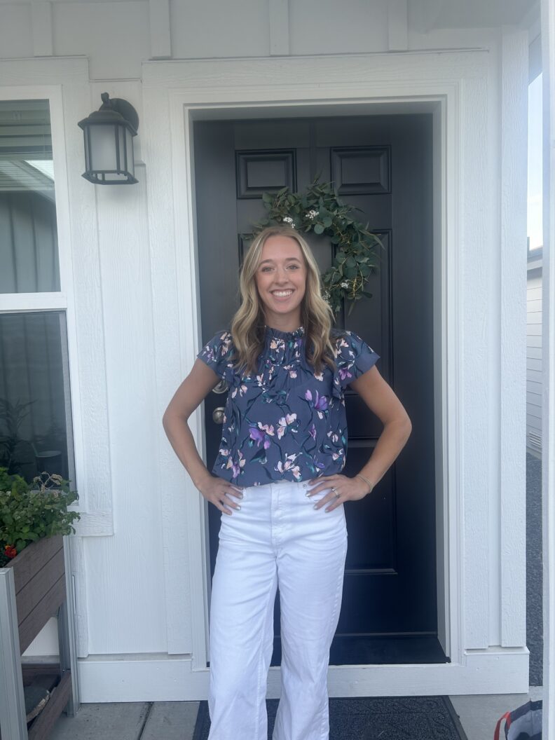 Ashlyn Belton Standing in front of a front door with hands on hip.