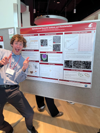 John Hewitt poses near research poster at SURCA.