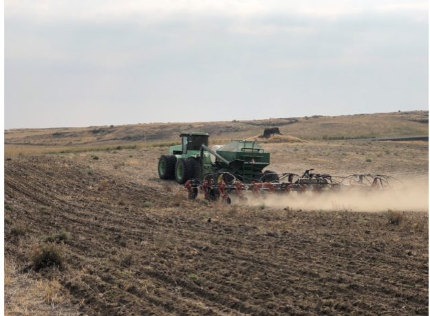 A tractor with a pull behind seeder