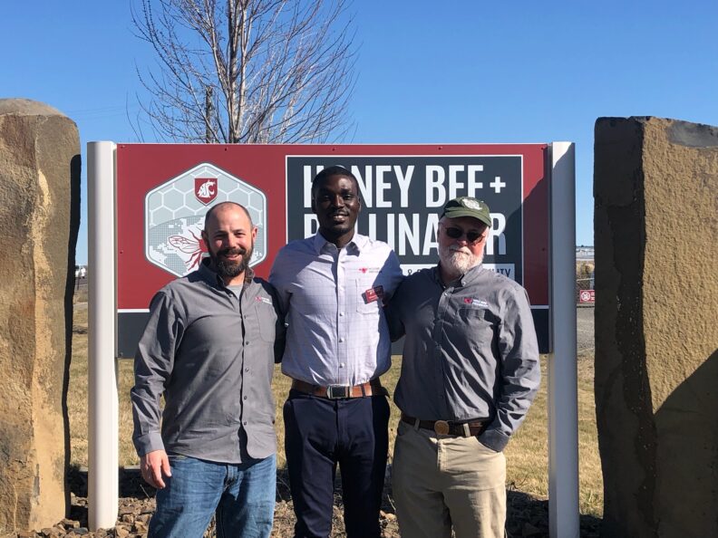 Left to right: Dr. Brandon Hopkins, Igbagbolere David, and Dr. Steve Sheppard, in front of the the Honey Bee + Pollinator Facility, Othello