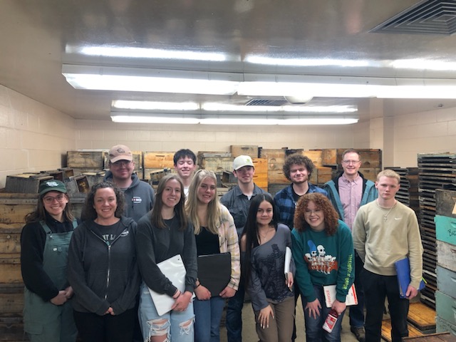 Members of the Pullman High School FFA group with members of the WSU bee team in the Pullman bee building