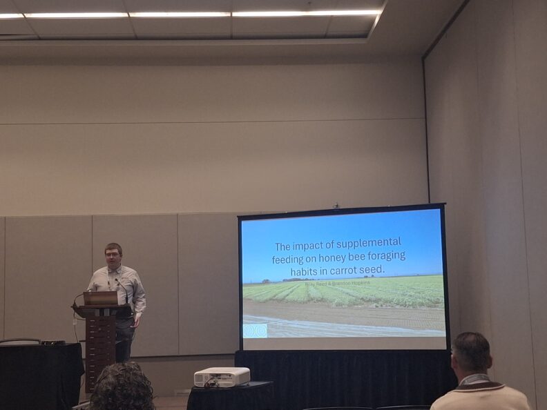 Riley at podium speaking about research