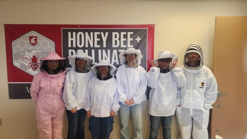 High school students dressed in bee suits at Othello Bee facility