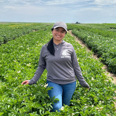 Francely Flores standing in a potato field.