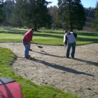 Two men working in a sandpit.