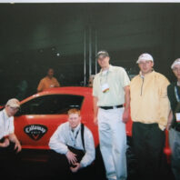 People posing with a car.