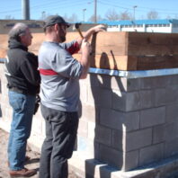 Two men hammering nails.