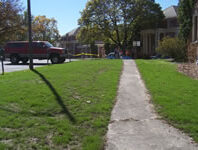 Lawn with houses in the background.