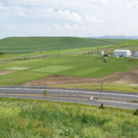Plots behind a road.