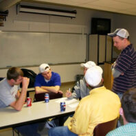 People sitting and standing around a table.