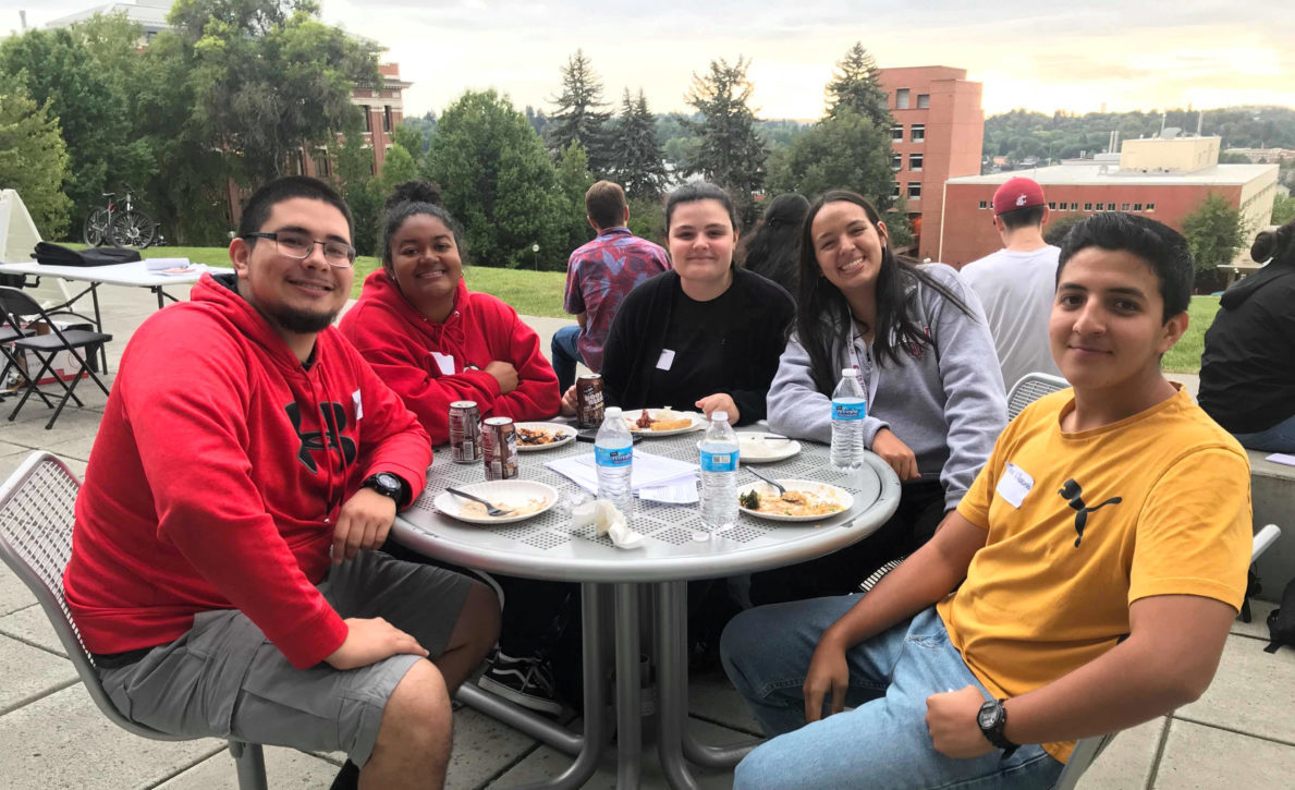 Students eating together outside at the LSAMP program's welcome back BBQ event.