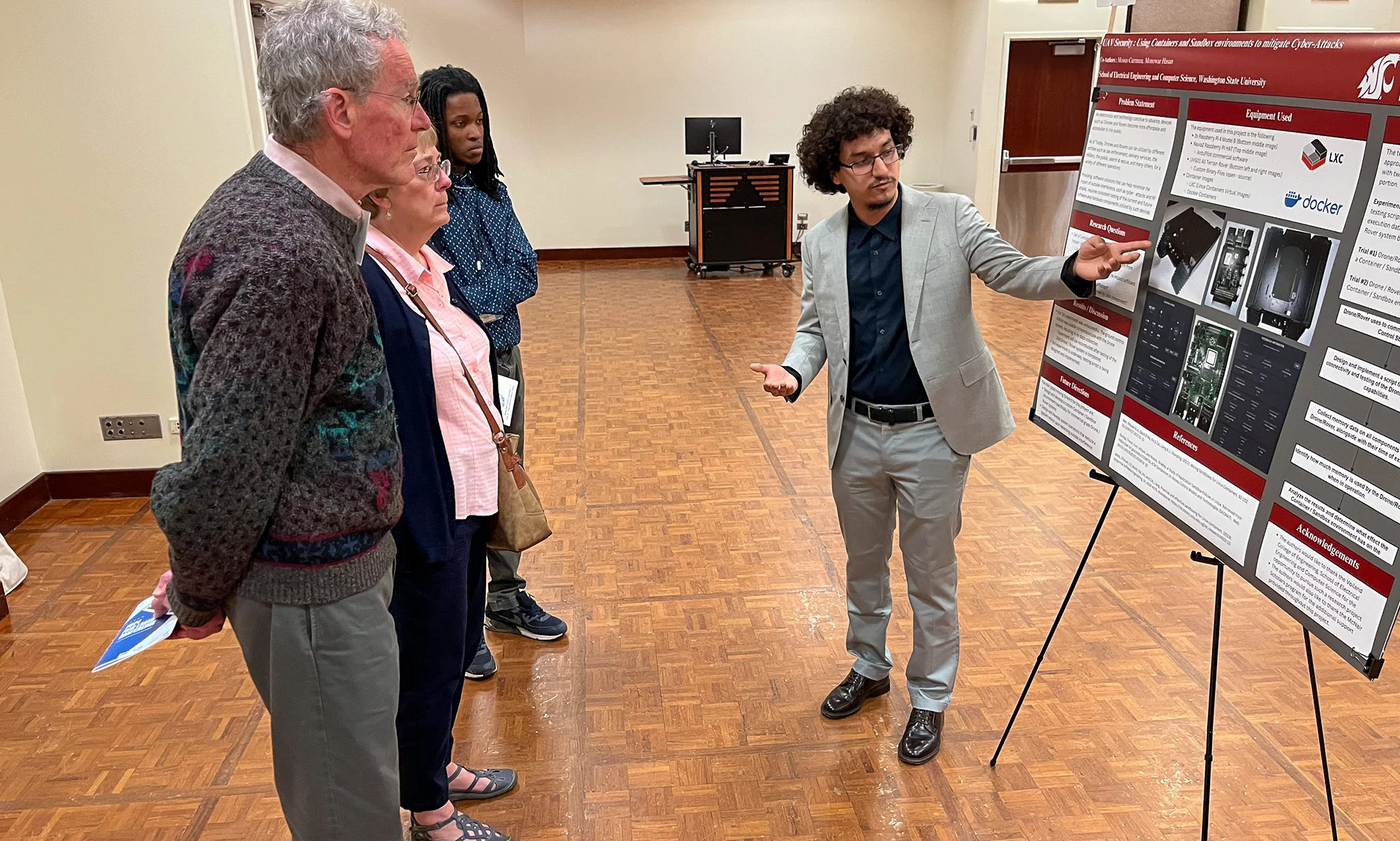 A WSU LSAMP student uses a research poster to present their work to three STEM professionals during the 2024 PNW LSAMP conference.