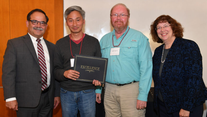 Provost Dan Bernardo and Vice Provost Erica Austin presenting a certificate to Bioengineering.