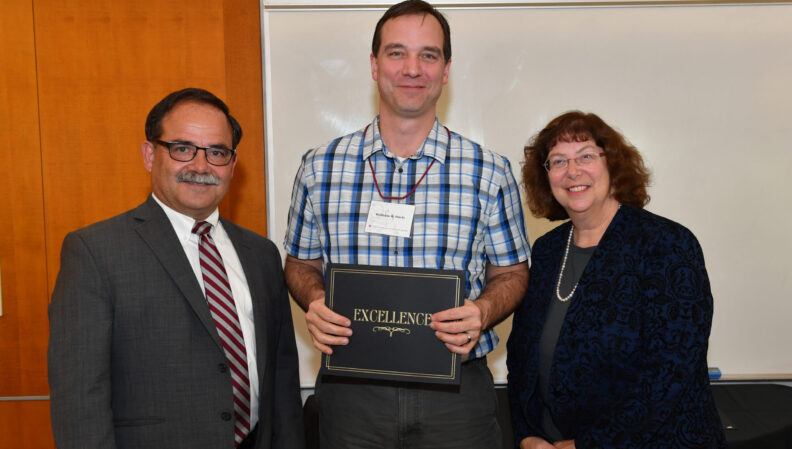 Provost Dan Bernardo and Vice Provost Erica Austin presenting a certificate to Molecular Biosciences.