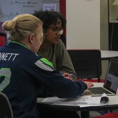 A tutor talks with a student in the writing center.