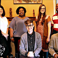 A diverse group of students and faculty pose for a group photo at a cultural exchange event.