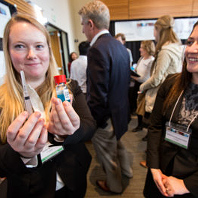 Two students share their undergraduate research project with a experts in their field at a symposium.