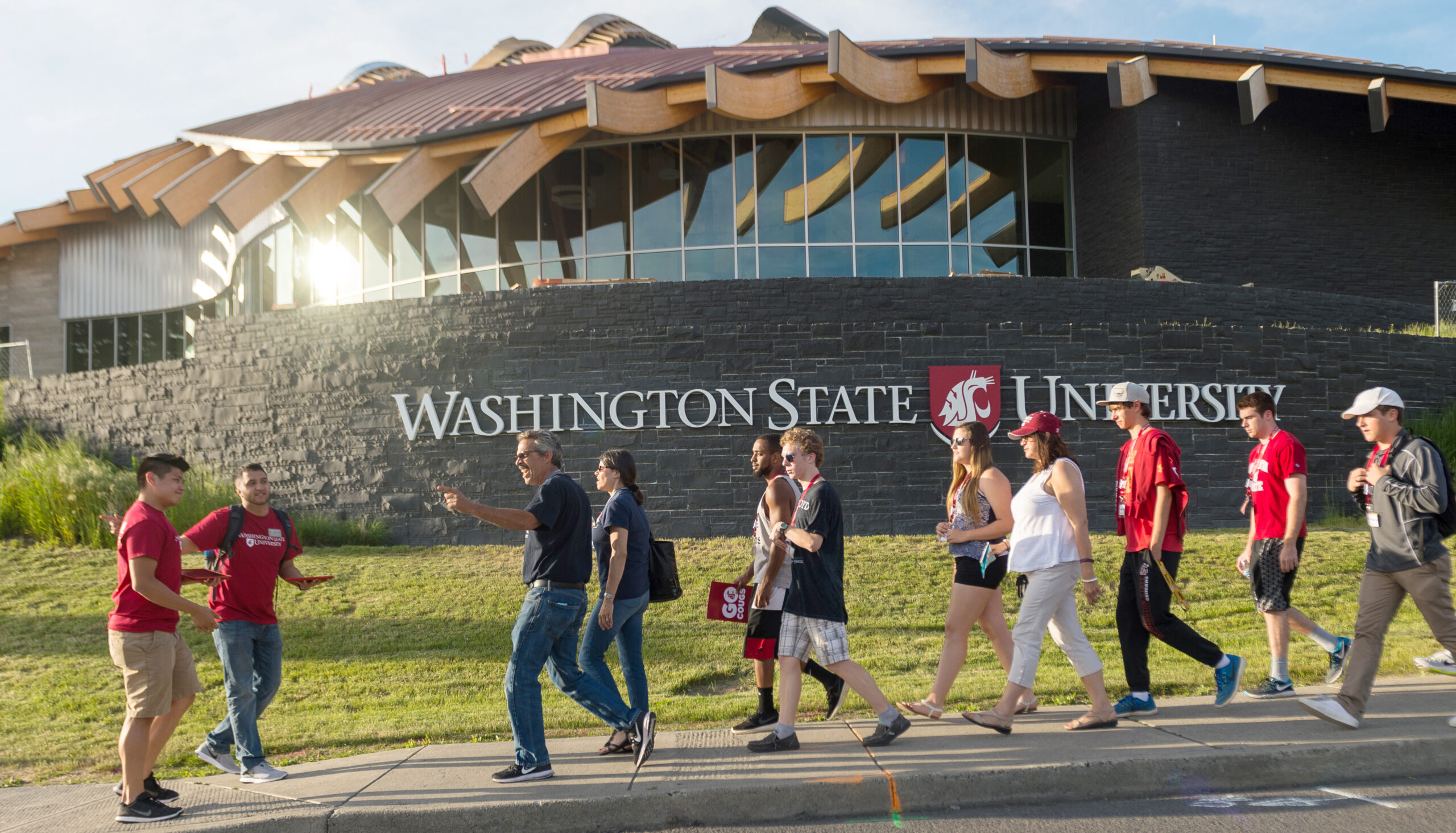 Students and parents walk down Stadium Way past the Elson S. Floyd Cultural Center during New Coug Orientation.