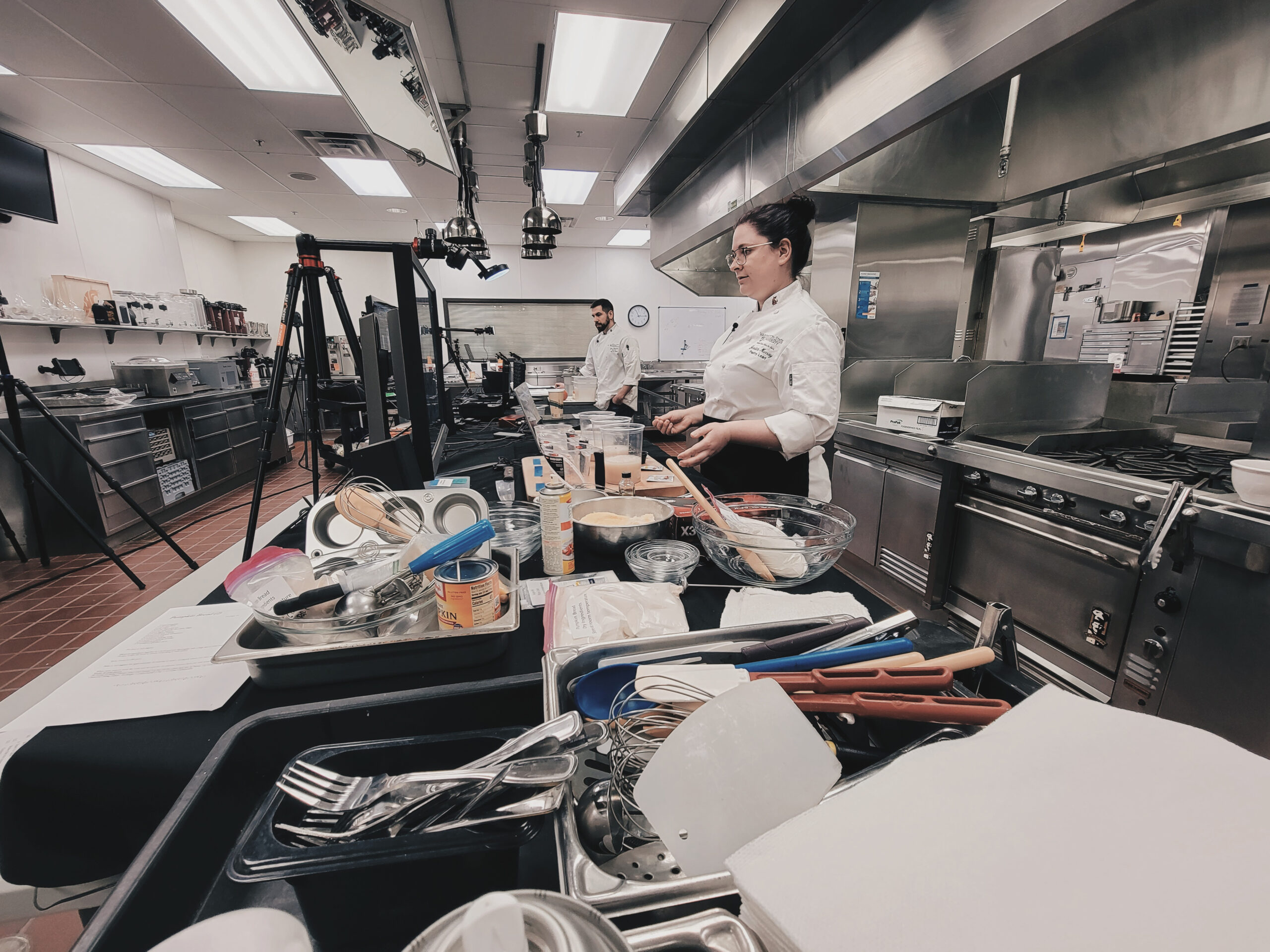 Jessica Murray, Hospitality Business Management Ph.D. student and teaching assistant, speaks to a camera during the virtual cooking class as it takes place in a professional kitchen.
