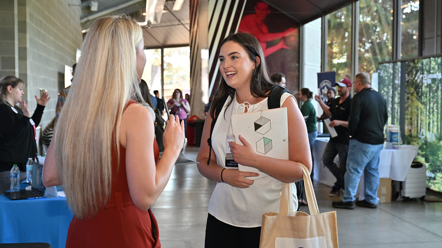An enthusiastic student speaks with a prospective employer at the annual career expo.